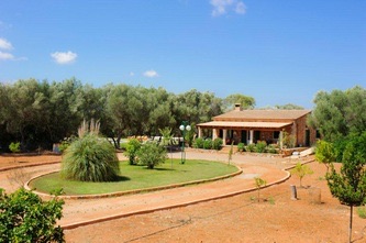 The stone farmhouse low among the trees, its circular garden and gravel drive in front